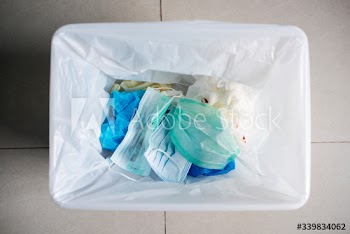 Used face masks in a contaminated waste bin