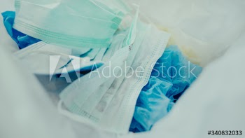 Used face masks in a contaminated waste bin