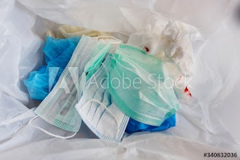 Used face masks in a contaminated waste bin