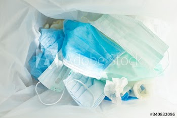 Used face masks in a contaminated waste bin