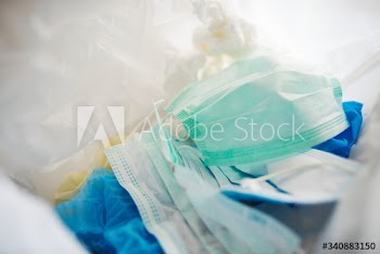 Used face masks in a contaminated waste bin
