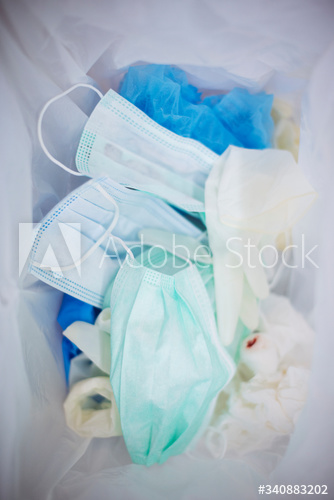 Used face masks in a contaminated waste bin
