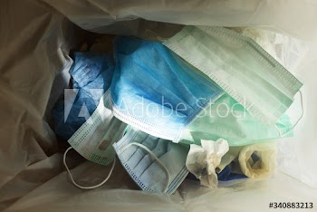 Used face masks in a contaminated waste bin