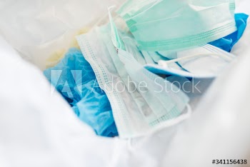 Used face masks in a contaminated waste bin