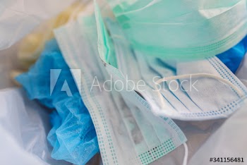Used face masks in a contaminated waste bin