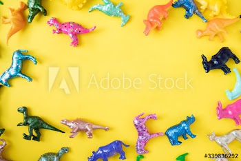 Various animal toy figures in a colorful background and a copyspace
