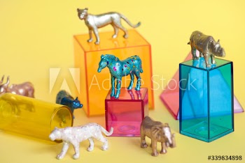 Various animal toy figures with boxes and in a colorful background