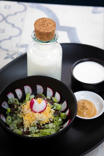 Vegetable Salad Beside Milk Bottle and Brown Sauce Dip on Round Black Tray