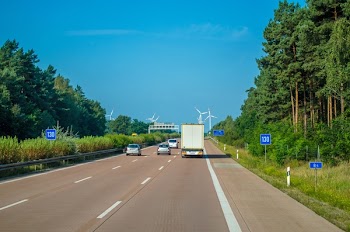 Vehicle Driving on Freeway Towards Wind Turbines