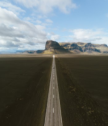 Vehicle in Road Near Stone Formation