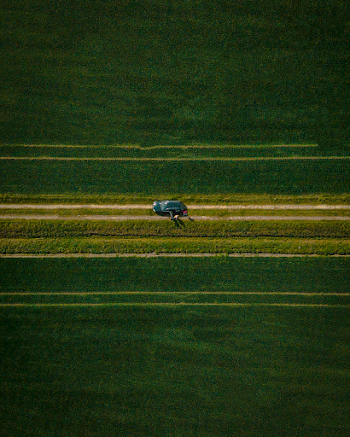 Vehicle On Road In The Middle Of Grass Field