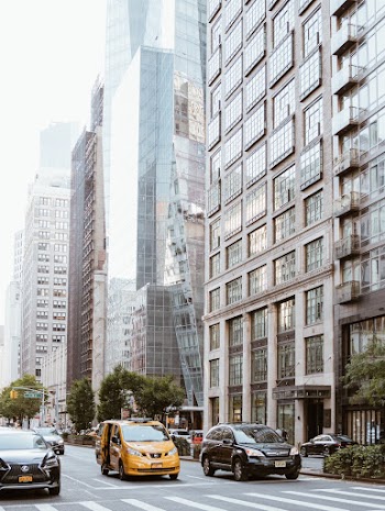 Vehicles On A City Street Lined With High-Rise Buildings 