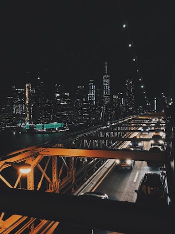 Vehicles on Bridge Under Black Sky