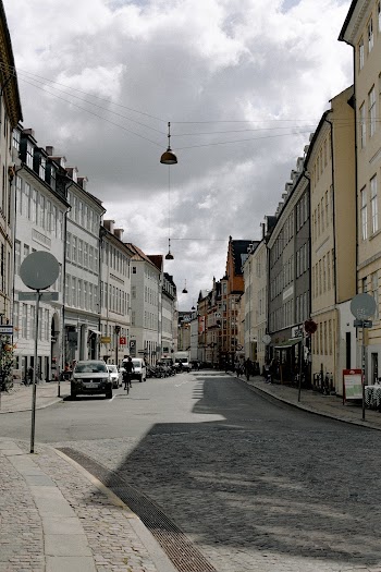 Vehicles on Road in Between Concrete Buildings