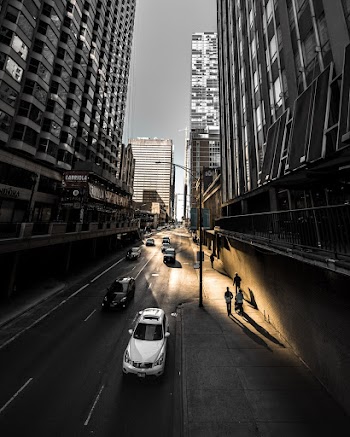 Vehicles on Road Surrounded by Buildings