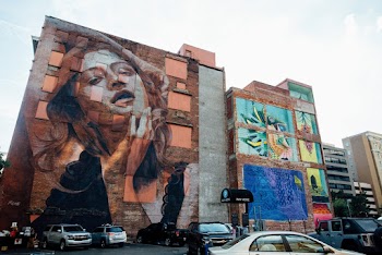 Vehicles Park Near Wall With Woman Graffiti