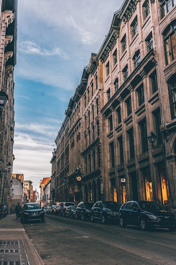 Vehicles Parked on Side of Street  Between Buildings