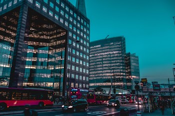 Vehicles Passing Near Two Black High-rise Building Under Blue Sky
