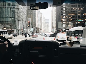 Vehicles Passing on Road in Between Buildings