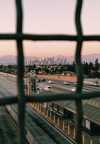 vehicles travelling road viewed from metal screen