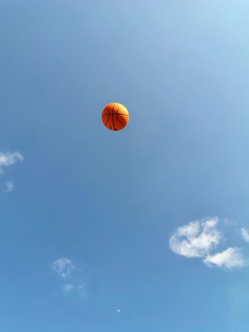 Vibrant Orange Balloon Floating in Clear Blue Sky