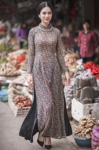 Vietnamese girl in Ao Dai walking on the market