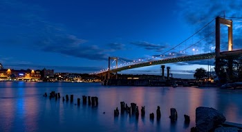 View of Body of Water Below City Suspension Bridge