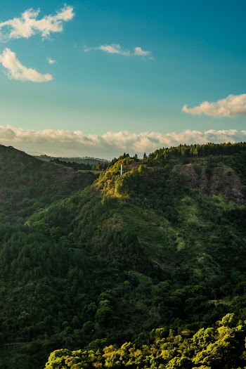 View of Green Hill Under Cloudy Sky