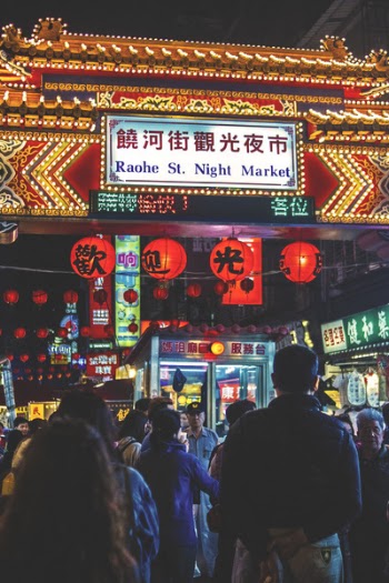 View of Raohe St. Night Market Arch With Kanji Texts and Group of People