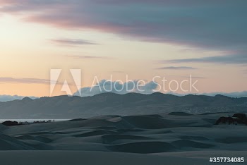 View of sand dunes against cloudy sky