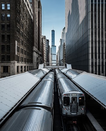View of Trains Between Highrise Buildings