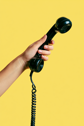 Vintage Black Telephone Handset Against Yellow Background
