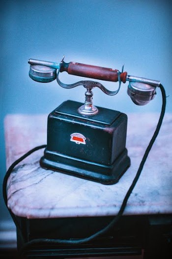 vintage blue and brown telephone on beige surface
