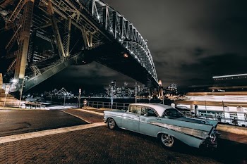 vintage blue car under the bridge during night time
