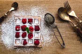 Waffle with sugar and raspberries 