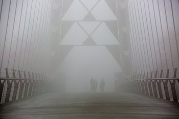 Walkers On Foggy Bridge