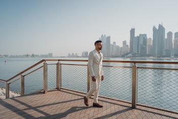 Walking Man Wearing White Suit Beside Fence