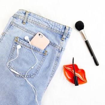 washed denim jeans and make-up brush