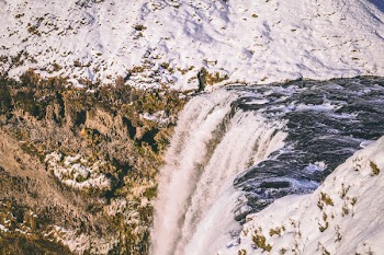 Water Falls Beside Mountains With Snow