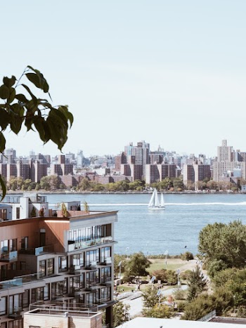 Water Front Building With The View Of The Cityscape Across The Sea