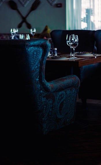 Water Goblets on Brown Wooden Table With Sofa Chairs
