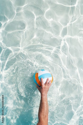 water polo player with a ball in a blue pool water. Top view. Copy space.