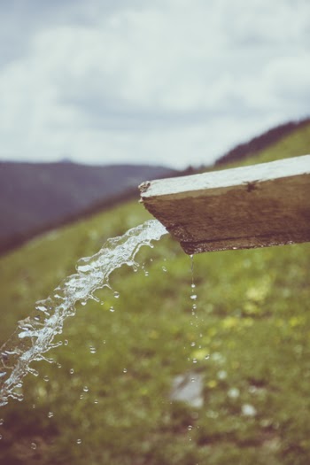 Water Pouring Thru Brown Wooden Cut Out Wood during Daytime