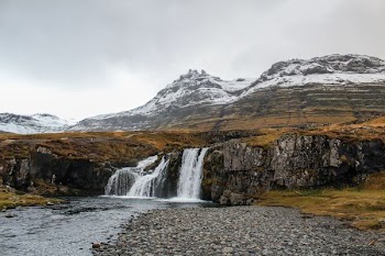 waterfalls and high mountain under cloudy sky