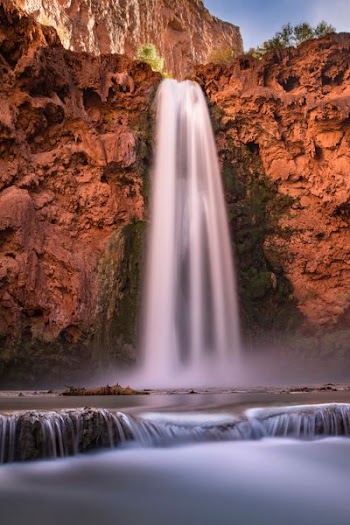 waterfalls between brown rock formation