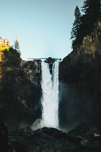 Waterfalls Near House Under Clear Blue Sky
