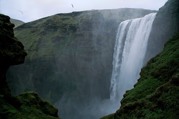 waterfalls surrounded by mountains