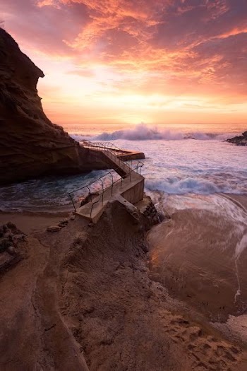 waves crashing on rocky coast during sunset