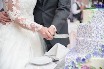 Wedding Couple Holding Knife While Cutting the Cake