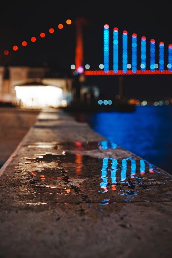 Wet Pavement Near Lighted Bridge